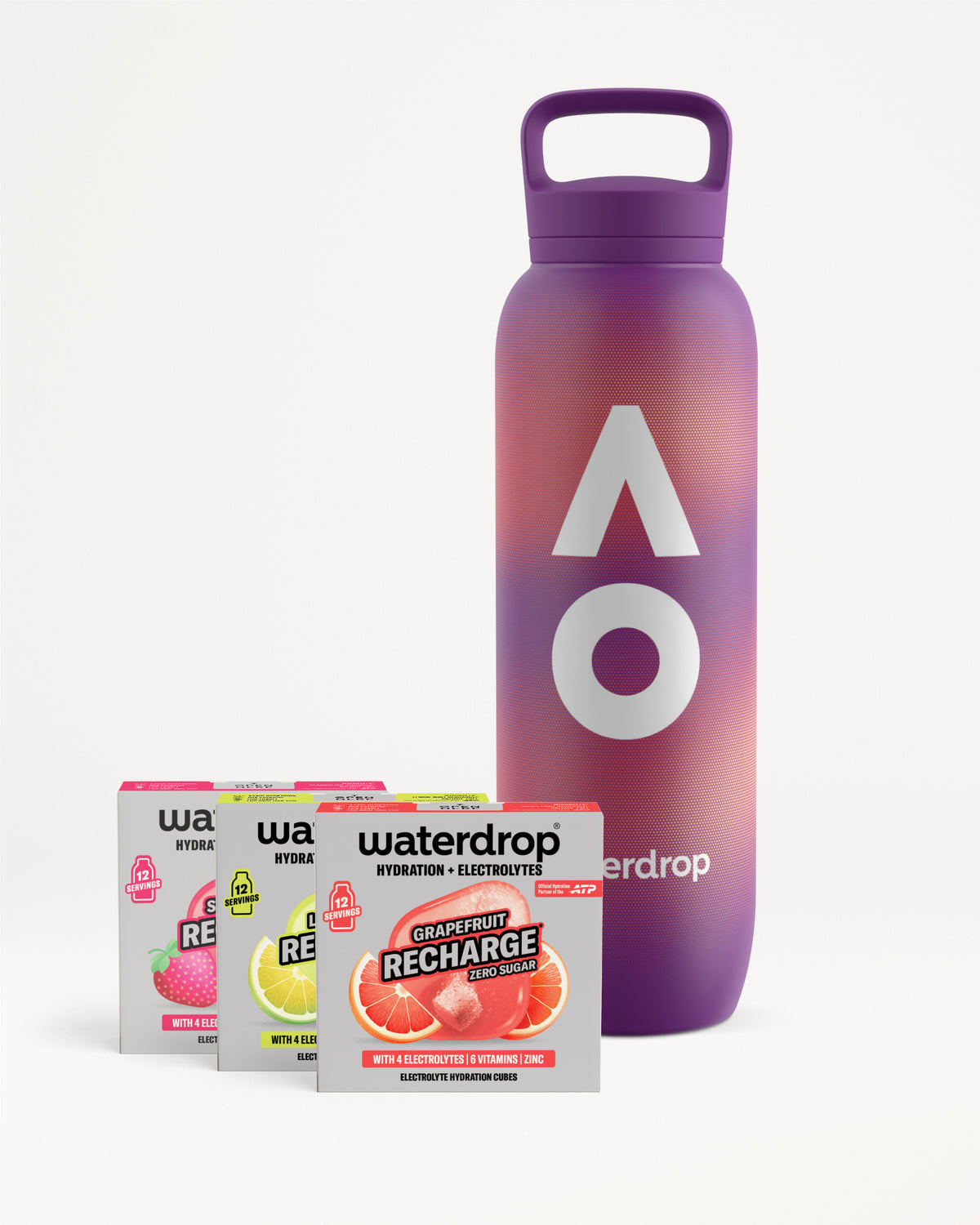 Lila waterdrop újrahasználható palack fogantyús kupakkal, mellette három cukormentes Recharge doboz Strawberry, Lemon-Mint és Grapefruit ízben, dobozonként 12 adaggal, fehér háttéren.