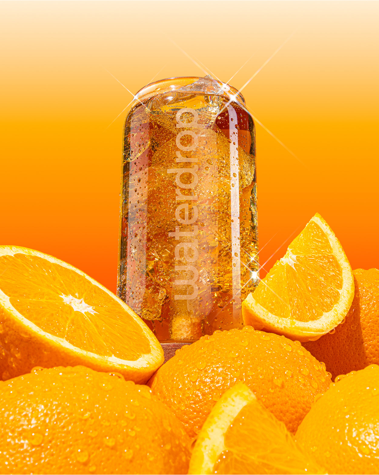 COLA ORANGE drink in waterdrop® branded glass with fresh oranges.