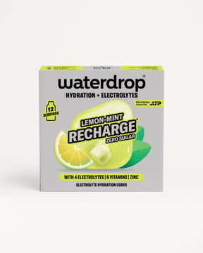 Elölnézetben bemutatott cukormentes Lemon-Mint Recharge doboz 12 adaggal, citrom- és mentaillusztrációkkal, valamint egy hidratáló kockával, fehér háttéren.