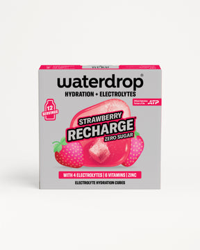 Elölnézetben bemutatott cukormentes Strawberry Recharge doboz 12 adaggal, eper illusztrációkkal és egy hidratáló kockával, fehér háttéren.