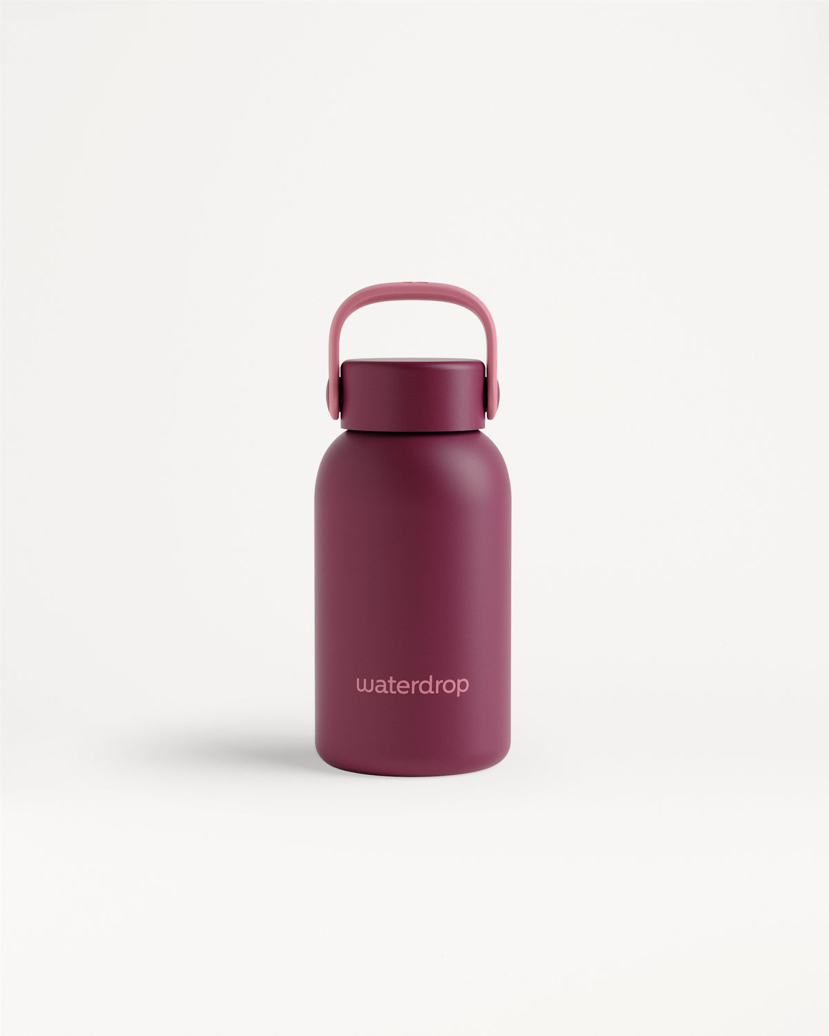 Magenta újrahasználható vizs bottle íl mentett fogantyúval fehér háttéren.
